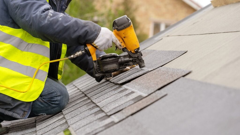 roofer installing new shingles on roof