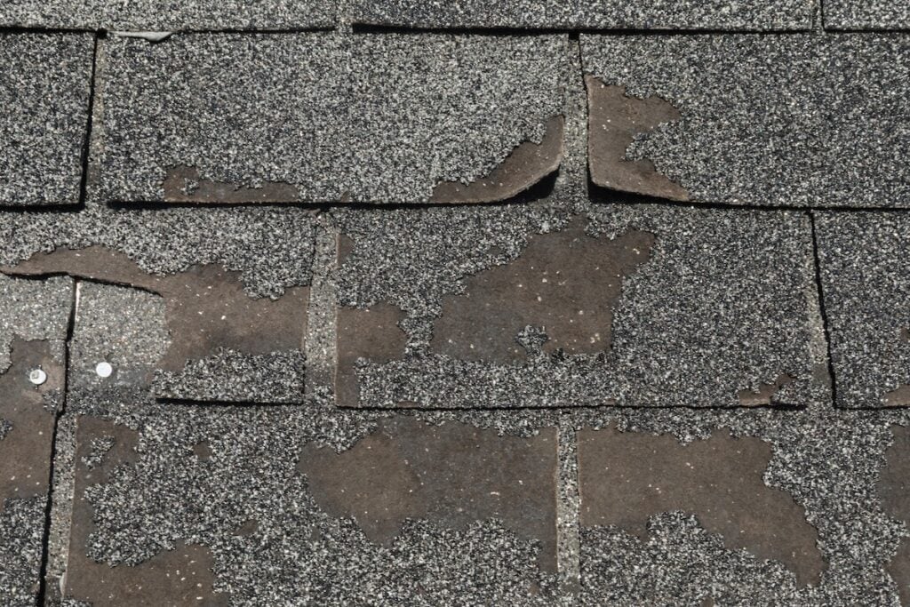 Roof in need of repair damaged asphalt roofing shingles architecture construction background texture pattern abstract concept