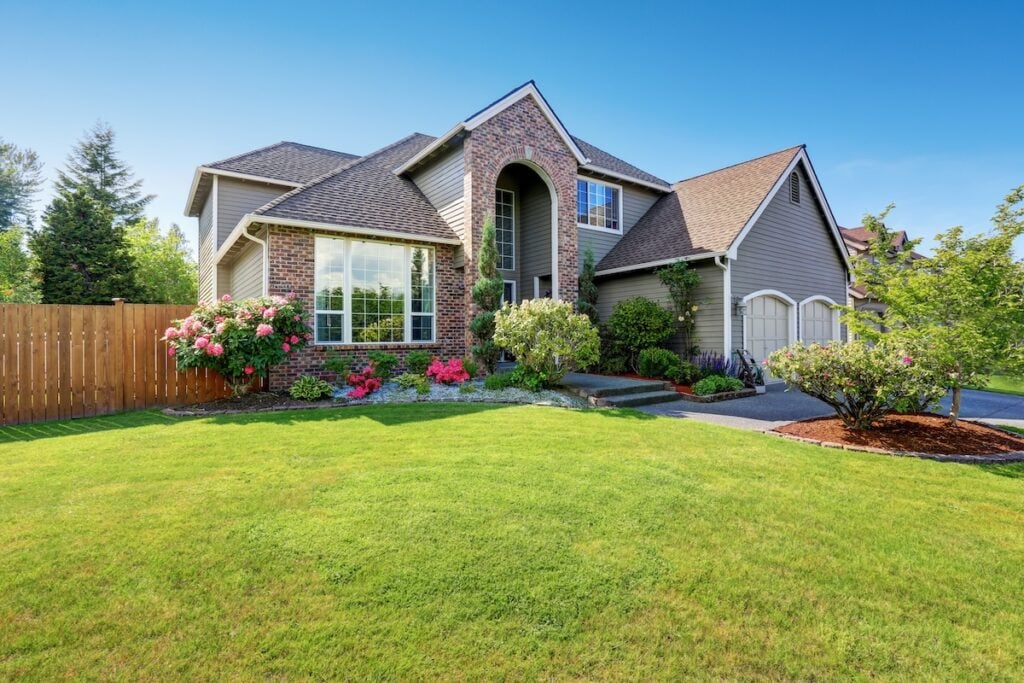 Luxury house exterior with brick and siding trim and double garage