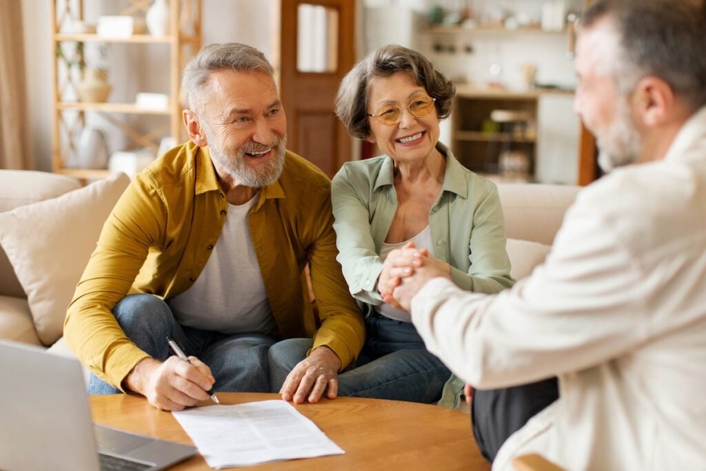 Happy senior couple of clients meeting with insurance agent
