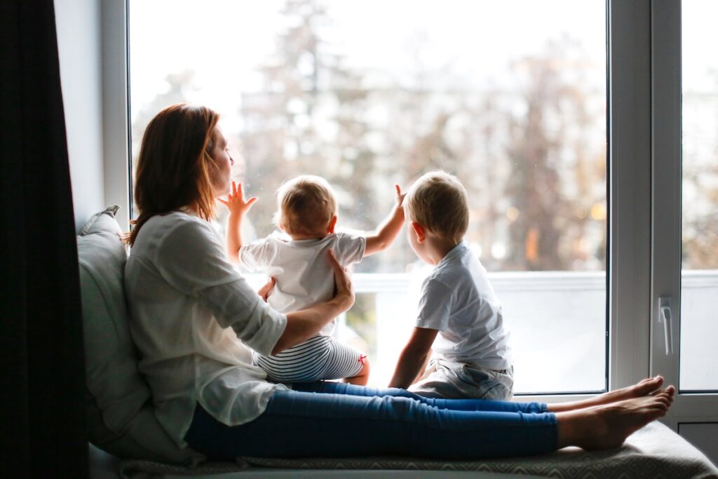 mom with two kids looking out the window